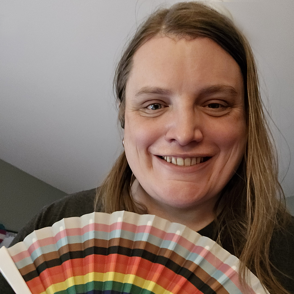 Morgan Whitten holding a Pride fan